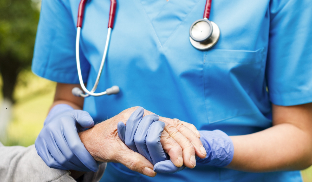 ممرضة تساعد رجل مسن مريض داخل دار رعاية مجهز لجميع الحالات المرضية