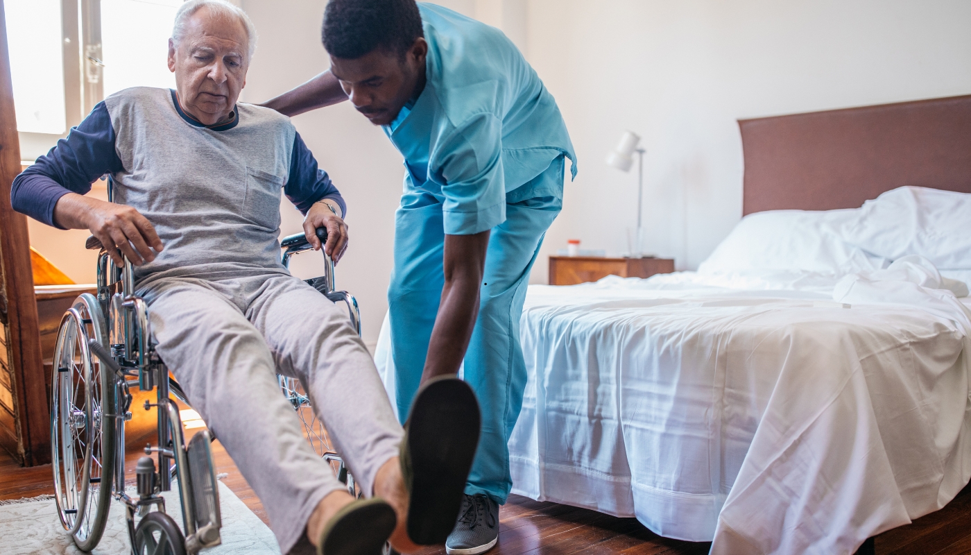 أخصائي علاج طبيعي يساعد رجلًا مسنًا على أداء تمارين التأهيل داخل دار رعاية طبية مجهزة في مصر