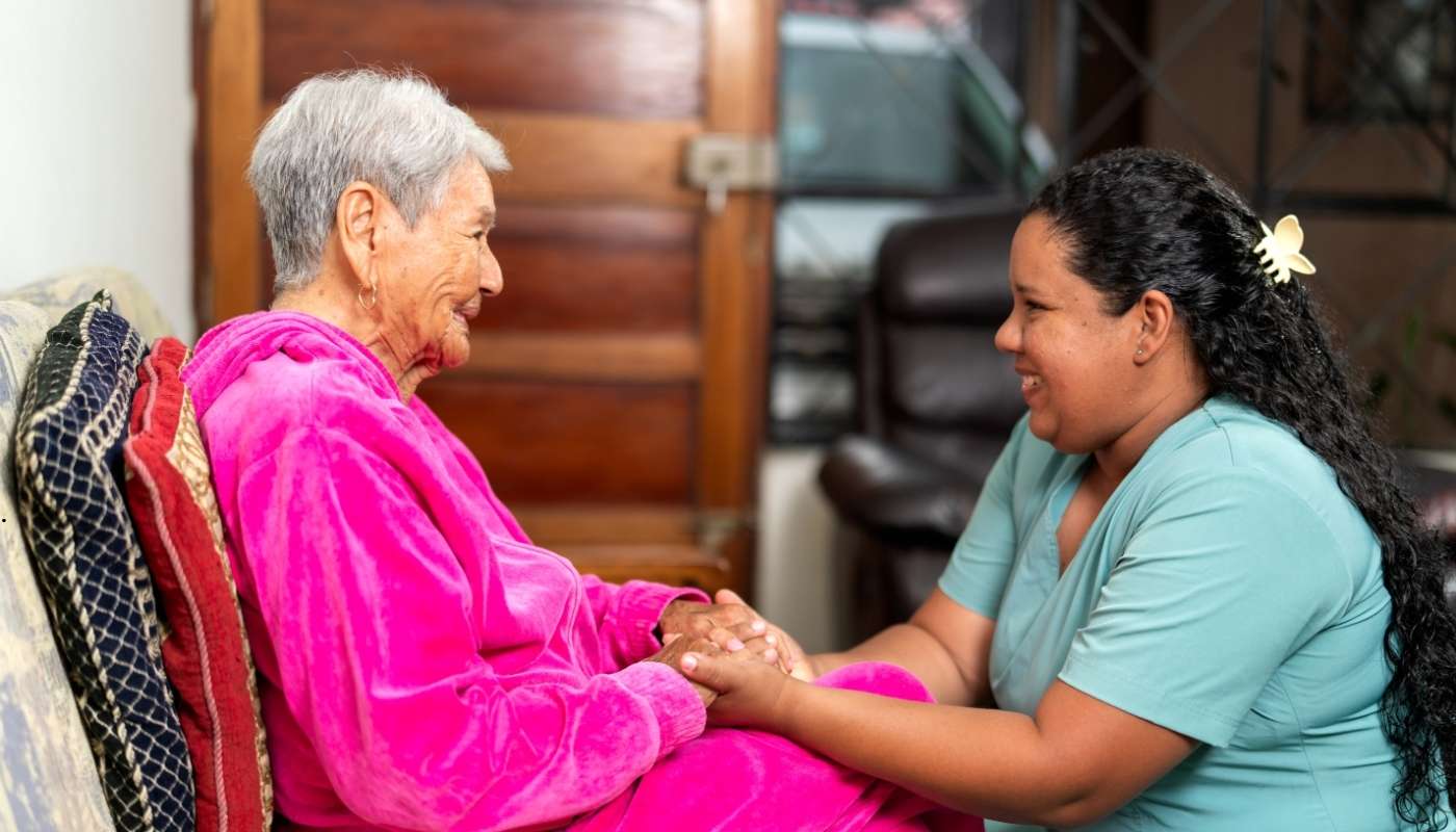 رجل مسن مبتسم يتلقى رعاية طبية وتمريضية في دار مسنين، يعكس أهمية رعاية الشيخوخة المتقدمة.