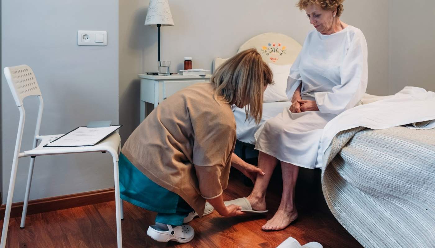 ممرضة تساعد مسن في الحركة اليومية.