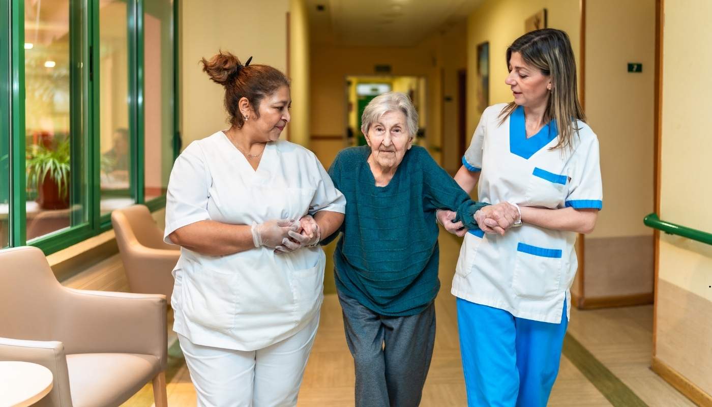 فريق عمل طبي وتمريضي يناقش خطة رعاية احترافية لمسن، يعكس الجانب المهني والتخصصي للرعاية.